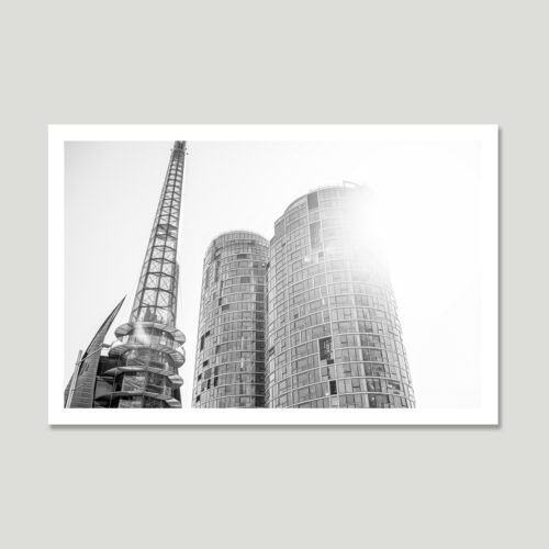 sunlit-structure_th Modern architecture in sunlight – a high-contrast black and white image of curved glass buildings and a steel tower.