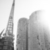 Modern architecture in sunlight – a high-contrast black and white image of curved glass buildings and a steel tower.